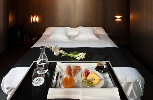 a hotel room with a tray of food on a bed at Caro Hotel in Valencia