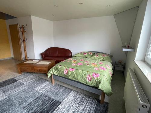 a bedroom with a bed and a chair and a table at 1 Zimmer Ferienwohnung 30 qm in Steinen
