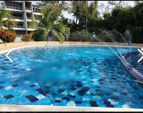 una gran piscina azul con una fuente en Condominio Terrazas del Sol, en Sopetrán