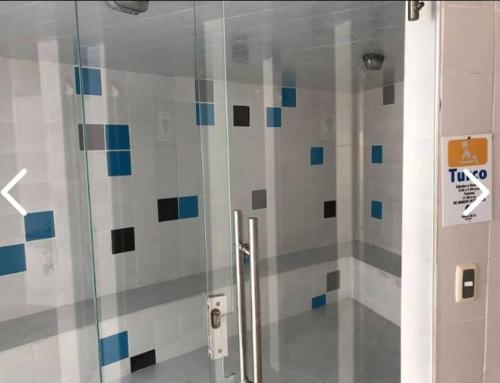 y baño con ducha y puerta de cristal. en Condominio Terrazas del Sol, en Sopetrán
