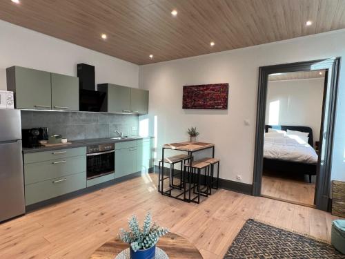 una cucina con tavolo e un letto in una camera di Jadore - Appartements meublés Mulhouse Ville a Mulhouse
