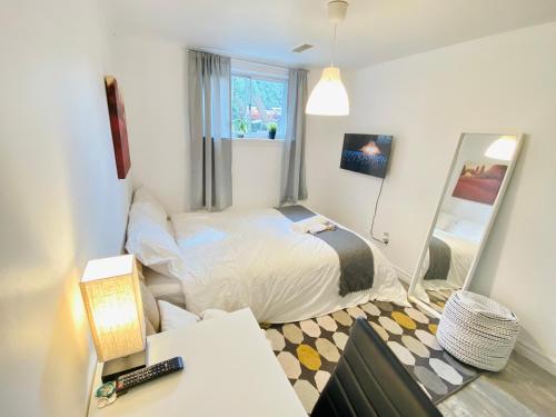 Dormitorio pequeño con cama y espejo en Sunrise Tree BnB - your Home away from home, en Toronto
