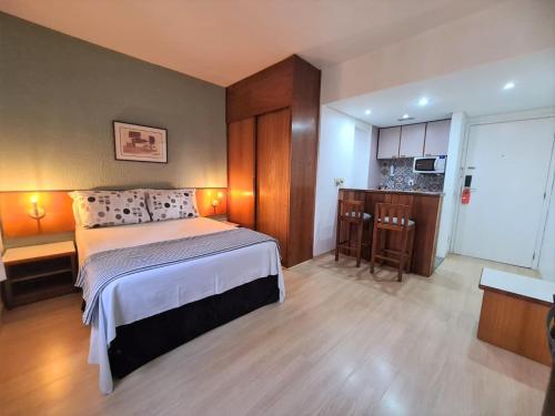 Una habitación de hotel con una cama y una cocina. en Qi Ibirapuera Intelligence Flat internet fibra e limpeza UH1903, en São Paulo