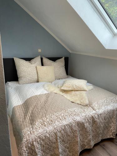 a bedroom with a bed with a white comforter and pillows at Neue Ferienwohnung im alten Forsthaus in Rüdesheim am Rhein