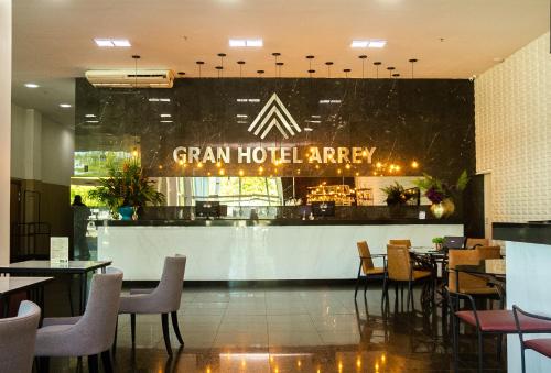 a restaurant with a bar and tables and chairs at Gran Hotel Arrey in Teresina