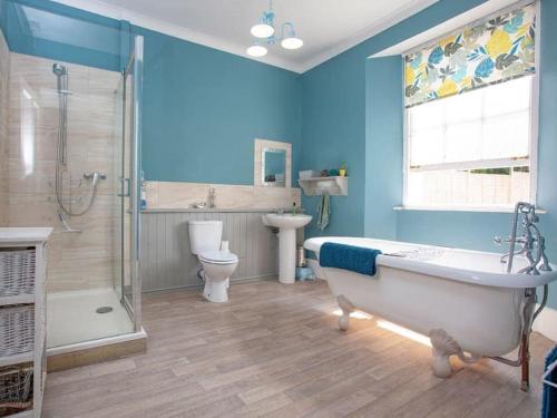 uma casa de banho com uma banheira, um chuveiro e um WC. em Glenthorne Villa Torquay em Torquay