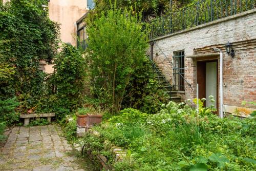 ein altes Backsteingebäude mit einem Garten davor in der Unterkunft Angelo Raffaele incantevole casa per 12 persone in Venedig