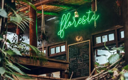 a neon sign on the wall of a restaurant at Hostel Da Vila Ilhabela in Ilhabela