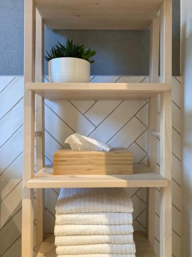 a wooden shelf with towels and a plant on it at Shelter in Zutendaal