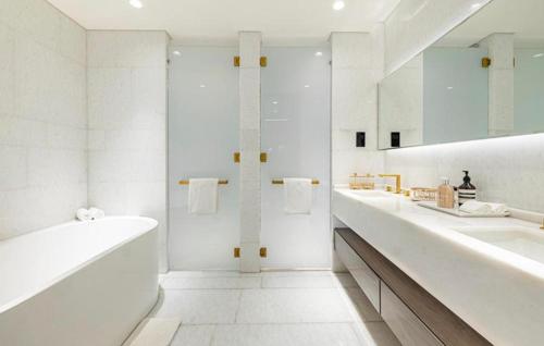 a white bathroom with two sinks and a large mirror at Five Palm Jumeirah Suites-Sea View in Dubai
