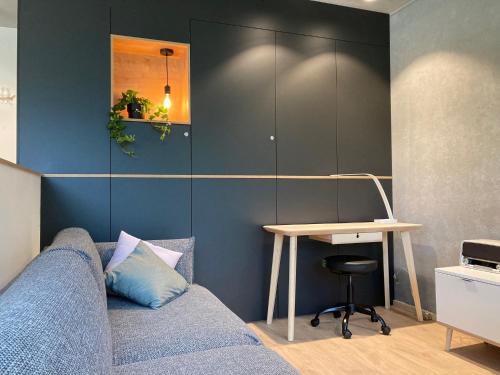 a living room with a couch and a desk at Shelter in Zutendaal