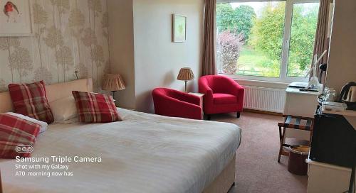 a bedroom with a bed and a chair and a window at Ornum House in Beauly