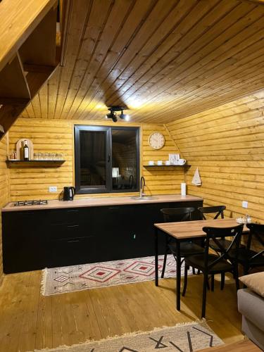 a kitchen with a counter and tables in a room at Eco cottage Kazbegi in Kazbegi