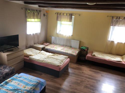 um quarto com 3 camas e uma televisão de ecrã plano em Apartament w domu przysłupowym 