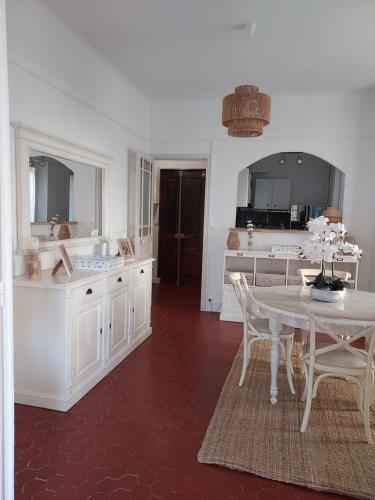 a kitchen with a white table and a table and chairs at Toulon soleil et douceur II in Toulon