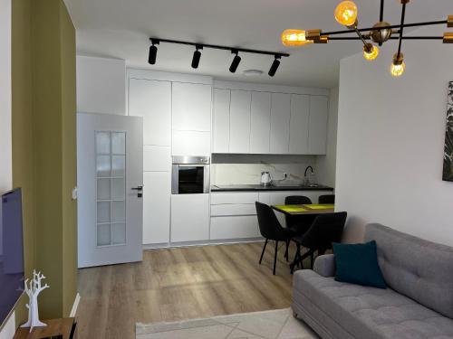 un soggiorno con un divano e un tavolo e una cucina di Blini Exclusive a Pristina