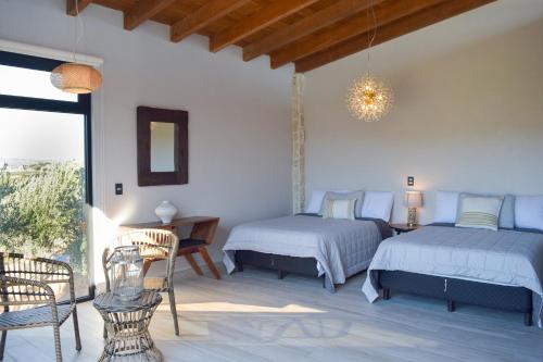a bedroom with two beds and a table and chairs at Valle Soléa in El Porvenir