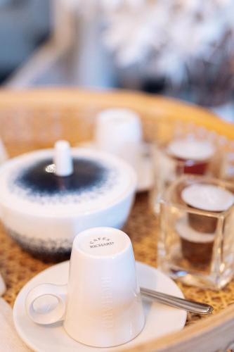 a table with a white coffee cup on a plate at Apolline in Fort-de-France