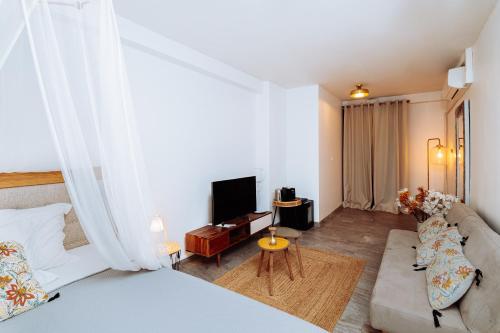 a room with a bed and a couch and a tv at Apolline in Fort-de-France