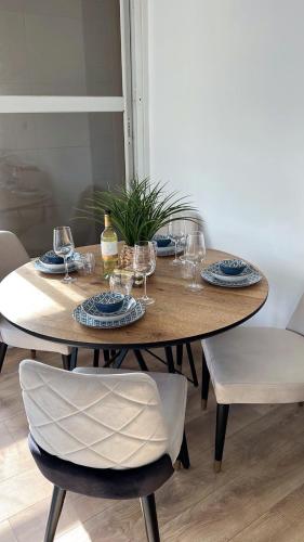 a wooden table with plates and wine glasses on it at The Symphony of the Breeze in Netanya