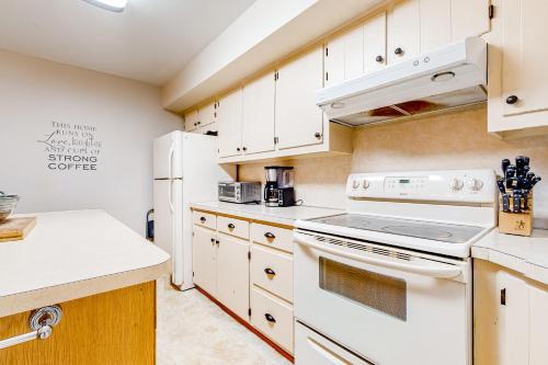 a kitchen with white appliances and white cabinets at The Cabin in Pocono Summit