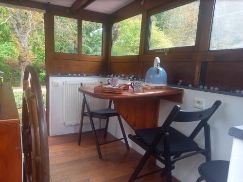 a kitchen with a table and chairs and windows at Appartement atypique indépendant sur péniche in Metz