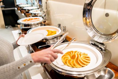 a person holding a plate of food in a kitchen at Holiday Inn Parramatta by IHG in Sydney