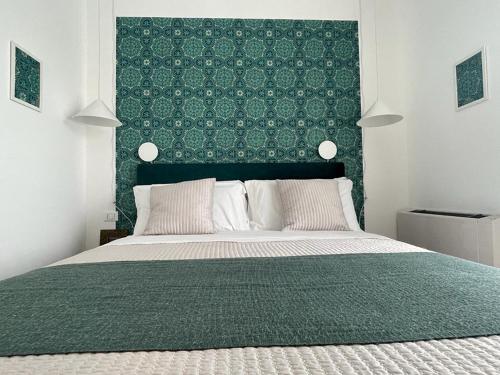 um quarto com uma cama grande e uma cabeceira verde em Tecnopolo Fiera Suite em Bolonha