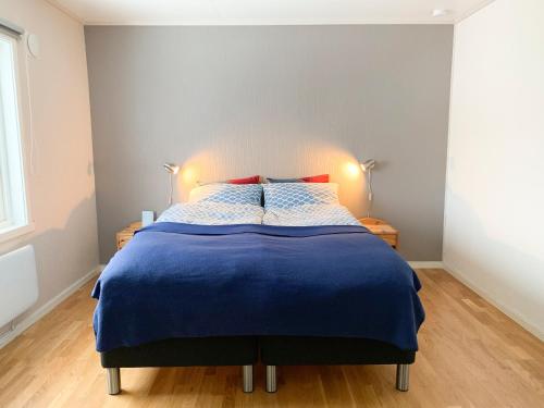 a bedroom with a bed with a blue comforter at Segla Guesthouse - Lovely sea view in Fjordgård