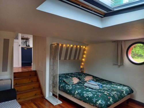 1 dormitorio con 1 cama en una habitación con ventana en Appartement atypique indépendant sur péniche, en Metz