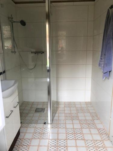 a bathroom with a shower and a tiled floor at Ferienhaus Woddow Uckermark in Woddow