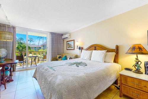 a bedroom with a large bed and a balcony at Islander on the Beach 235 in Kapaa