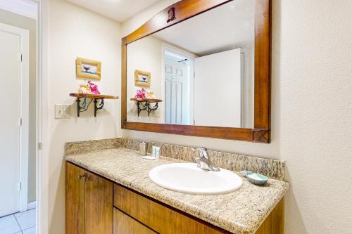 a bathroom with a sink and a large mirror at Islander on the Beach 235 in Kapaa