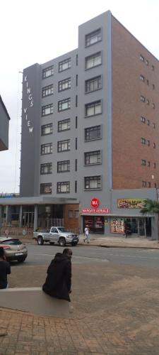 a person sitting on a bench in front of a building at Kingsview 201 in Margate