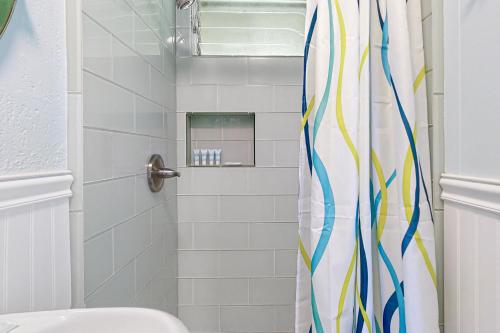 La salle de bains est pourvue d'une douche avec un rideau de douche coloré. dans l'établissement Kapa'a Sands 09, à Kapaa