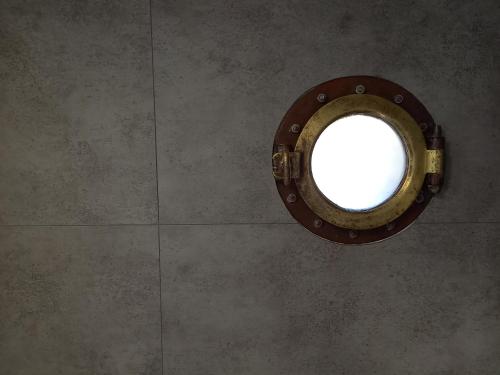 a round window on a wall in a room at Appartement atypique indépendant sur péniche in Metz
