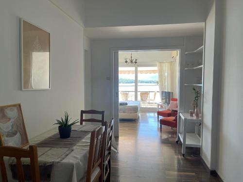 a dining room with a table and a living room at Marine Apartment with sea & port view! in Volos