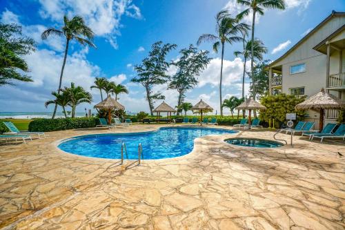 a swimming pool at a resort with palm trees at Islander on the Beach 333 in Kapaa