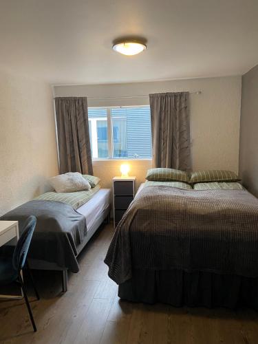 a bedroom with two beds and a window at The Little Guesthouse Downtown - Keflavik Airport in Keflavík