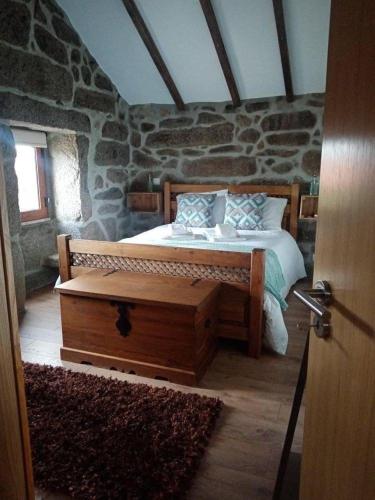 a bedroom with a bed in a stone wall at BezerreiraComVida-O refúgio do monte in Bezerreira