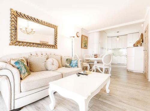 Playa San Juan apartment في بلايا دي سان خوان: غرفة معيشة مع أريكة بيضاء وطاولة