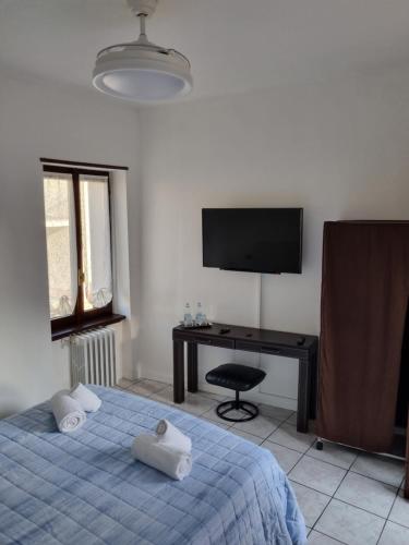 Schlafzimmer mit einem Bett, einem Schreibtisch und einem TV in der Unterkunft SWEET HOME in Azzano San Paolo