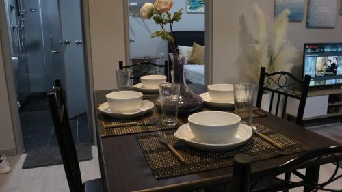 a dining room table with plates and bowls on it at MLH Designer Suites @ Jesselton Quay CityPads in Kota Kinabalu