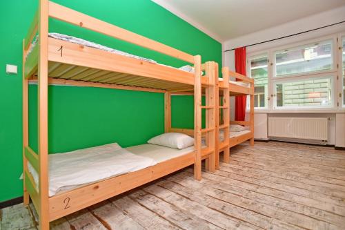 two bunk beds in a room with a green wall at Prague Old Town Hostel in Prague