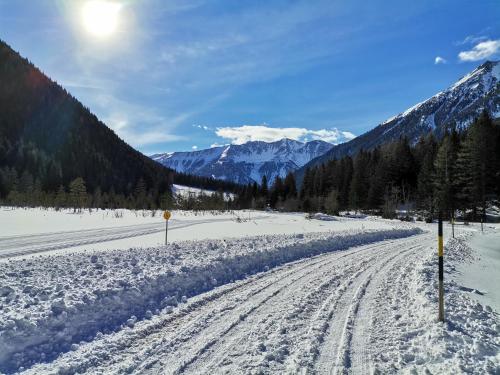 a snow covered road with mountains in the background at AH Carinthia Mallnitz - Carinthia Appartements in Mallnitz