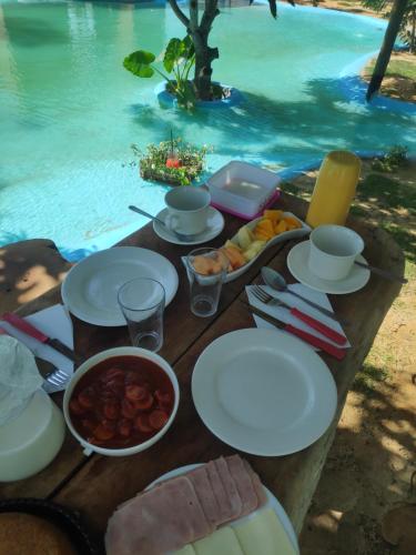 stół z talerzami żywności obok wody w obiekcie Anacardium w mieście Canoa Quebrada
