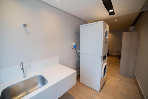 a kitchen with a sink and a refrigerator at Charlie Dstay Moema in Sao Paulo