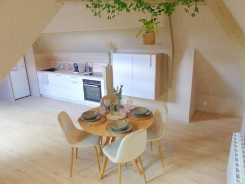 uma mesa de jantar e cadeiras numa cozinha em Le Green Cosy em Évreux