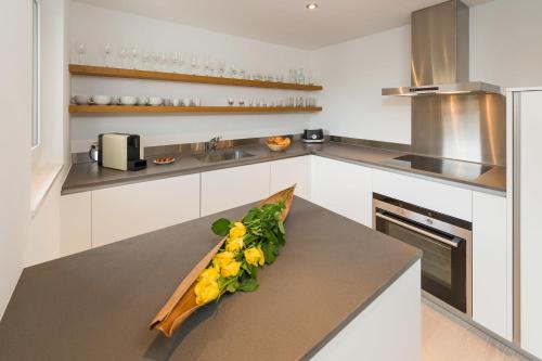 a kitchen with a bouquet of flowers on a counter at Casa delle Stelle by Zermatt Premium Apartments in Zermatt