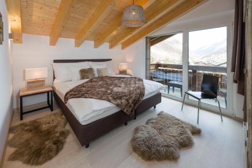 a bedroom with a bed and a large window at Casa delle Stelle in Zermatt